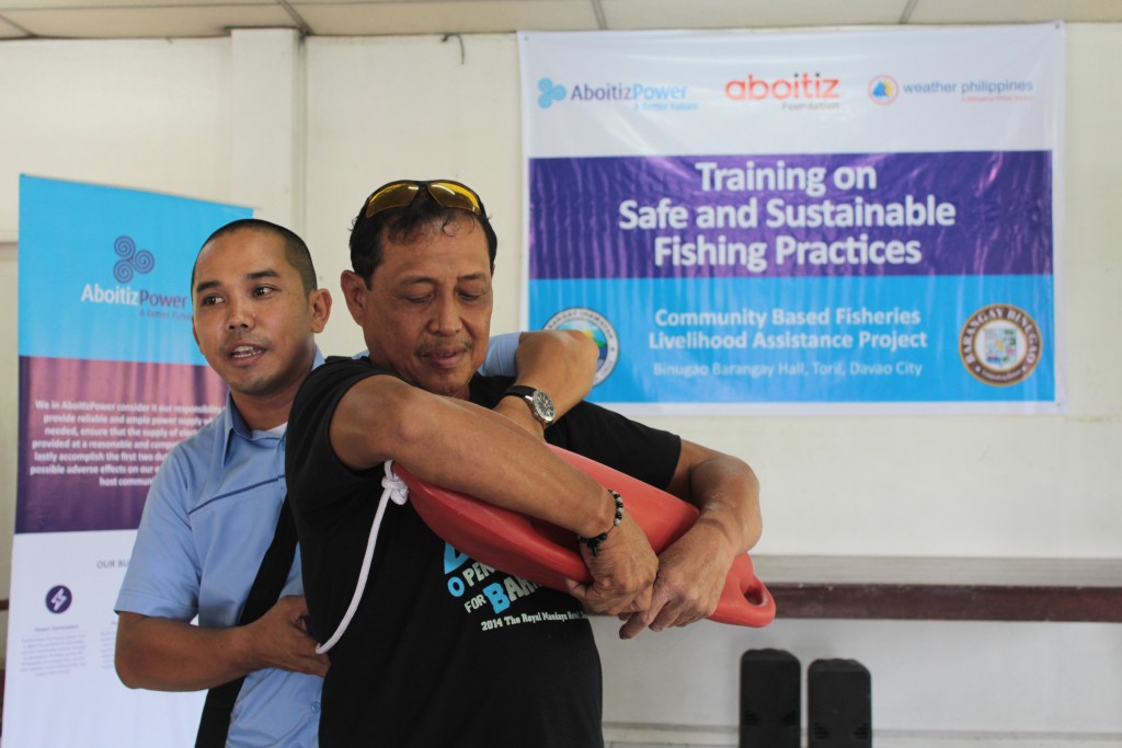 TSI Safety Technician Jimmie Carlo Berdos, with the help of Brgy. Binugao Kagawad Romeo Saniel, demonstrates to the fishermen of Barangay Binugao, Toril, Davao City on the use of a rescue can.