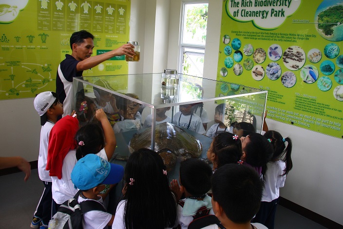 Davao Light and Power Co. Community Relations Manager Fermin Edillon shows and explains about the preserved pawikan eggs and hatchling in the Learning Center of the Cleanergy Park to the SMILE Learners.